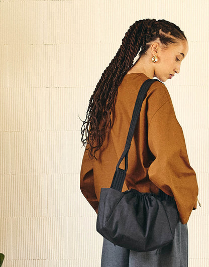 Cross-body bag, two wide side pockets, drawstring closing, adjustable padded shoulder strap.
Made in France, in a Black ripstop canvas, 100% Cotton, 206g/m², from a fashion house's dead stock.
Also available in a maxi version.