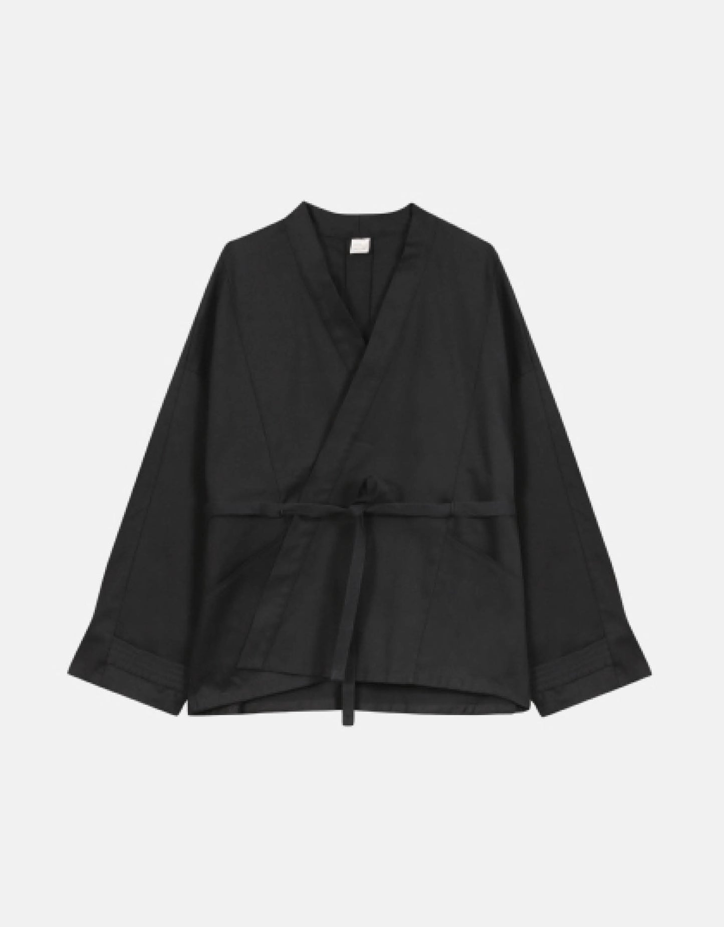 Unisex jacket, straight cut, oversized, low armholes, quilted strap at bottom of sleeves to modify volume, two wide pockets, asymmetrical lines, two wide pleats in back, cross-over front, closed by a belt.
Made in France, in a Black stretch cotton gabardine, 98% Cotton, 2% Elastane, 251g/m², from a fashion house's dead stock.