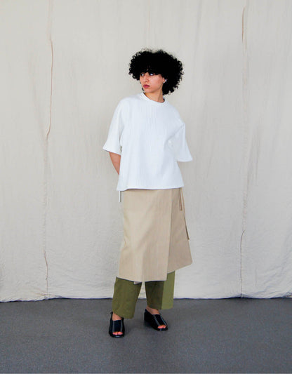 Jupe Chapitre 1, portefeuille, deux poches latérales, taille ajustable avec cordons passant dans deux passants au dos, dans un camaïeu de denims beiges.  Chapter 1 skirt, wrapped, two side pockets, adjustable waist with drawstrings passing through two loops at the back, in a cameo of beige denim.