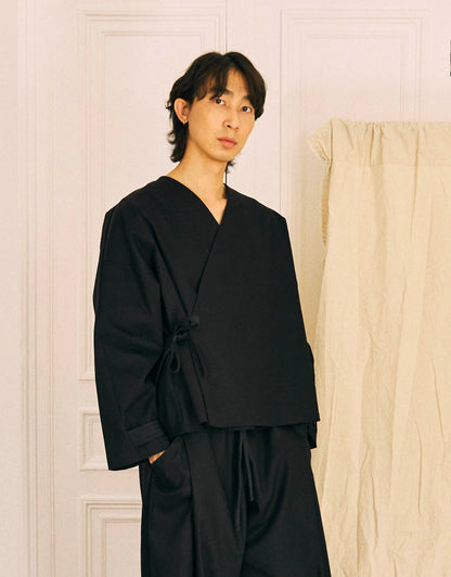 Unisex kimono, straight cut, oversized, low armholes, quilted strap at the bottom of the sleeves to modify volume, asymmetrical lines, cross-over front, closes with cotton taffeta ties of different widths. Designed to be worn both closed and open as an overshirt.&nbsp;

Made in France, in a Black stretch cotton gabardine, 98% Cotton, 2% Elastane, 251g/m², from a fashion house's dead stock.