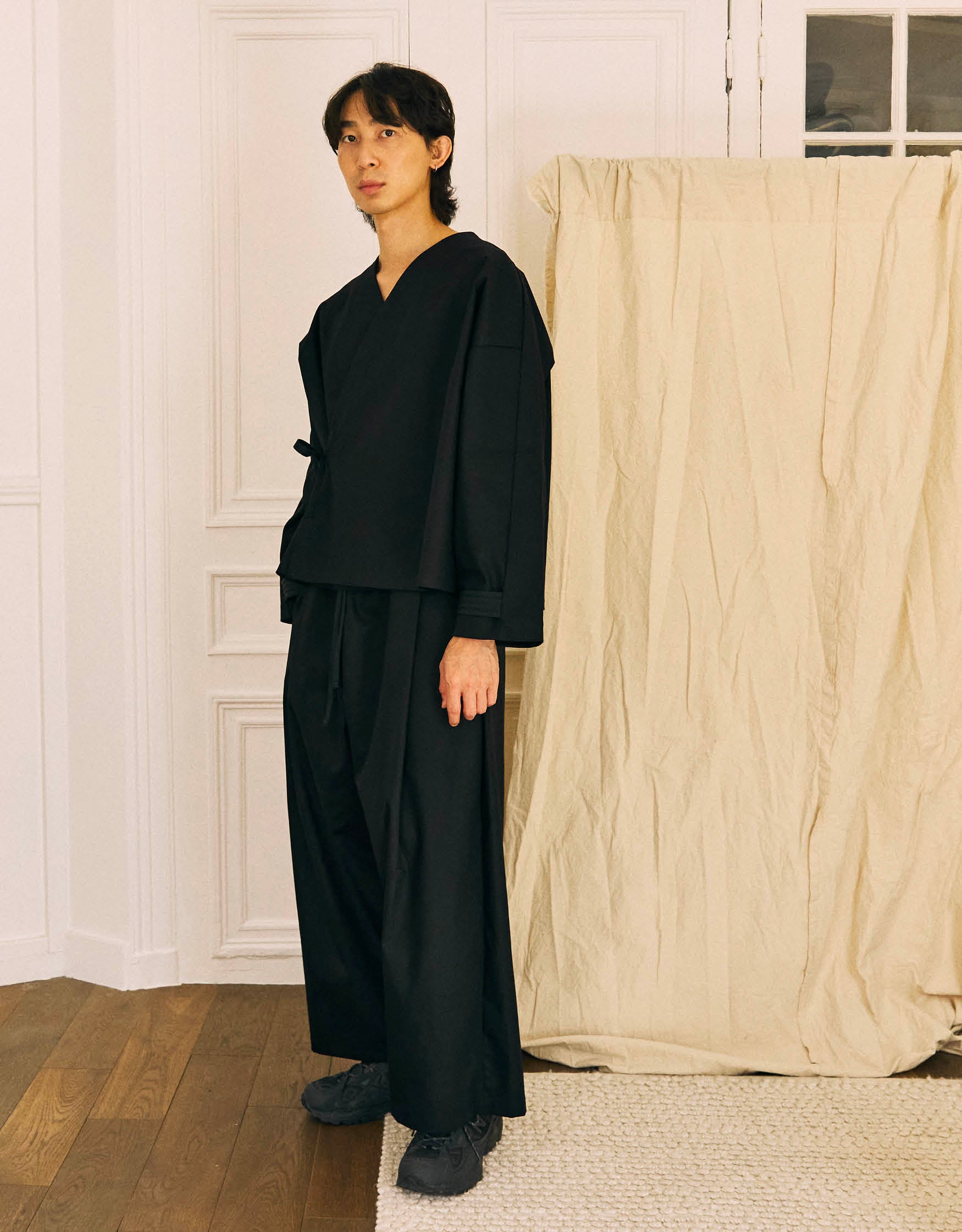 Unisex kimono, straight cut, oversized, low armholes, quilted strap at the bottom of the sleeves to modify volume, asymmetrical lines, cross-over front, closes with cotton taffeta ties of different widths. Designed to be worn both closed and open as an overshirt.&nbsp;

Made in France, in a Black stretch cotton gabardine, 98% Cotton, 2% Elastane, 251g/m², from a fashion house's dead stock.