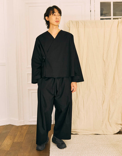 Unisex kimono, straight cut, oversized, low armholes, quilted strap at the bottom of the sleeves to modify volume, asymmetrical lines, cross-over front, closes with cotton taffeta ties of different widths. Designed to be worn both closed and open as an overshirt.&nbsp;

Made in France, in a Black stretch cotton gabardine, 98% Cotton, 2% Elastane, 251g/m², from a fashion house's dead stock.