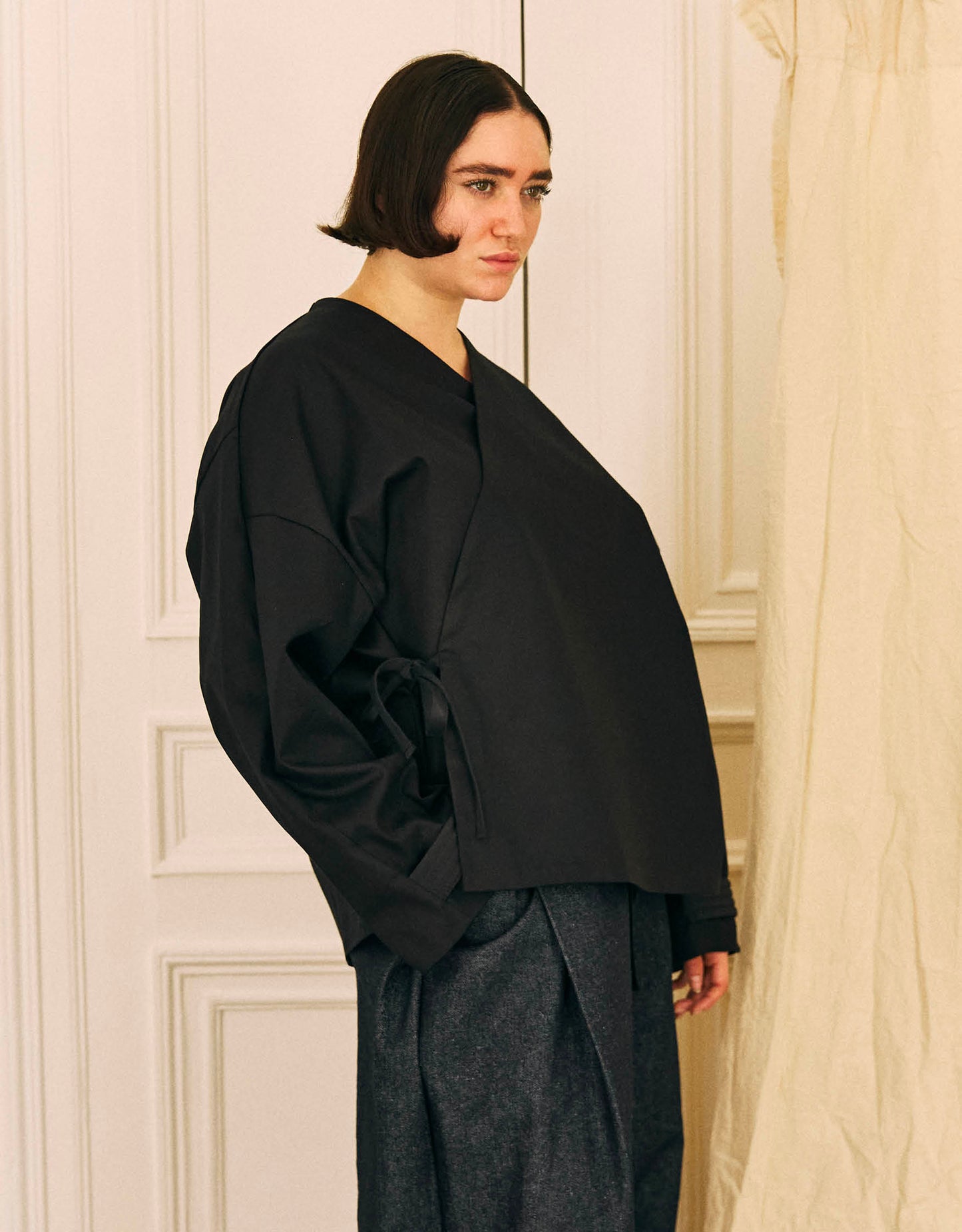 Unisex kimono, straight cut, oversized, low armholes, quilted strap at the bottom of the sleeves to modify volume, asymmetrical lines, cross-over front, closes with cotton taffeta ties of different widths. Designed to be worn both closed and open as an overshirt.&nbsp;

Made in France, in a Black stretch cotton gabardine, 98% Cotton, 2% Elastane, 251g/m², from a fashion house's dead stock.