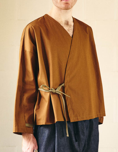 Unisex kimono, straight cut, oversized, low armholes, quilted strap at bottom of sleeves to modify volume, asymmetrical lines, cross-over front, closes with cotton taffeta ties of different widths. Designed to be worn both closed and open as an overshirt.
Made in France, in a Bronze ripstop canvas, 100% Cotton, 206g/m², from a fashion house's dead stock.