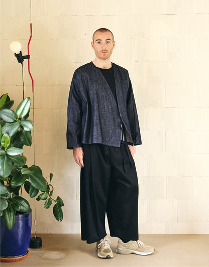 Unisex kimono, straight cut, oversized, low armholes, quilted strap at bottom of sleeves to modify volume, asymmetrical lines, cross-over front, closes with cotton taffeta ties of different widths. Designed to be worn both closed and open as an overshirt.
Made in France, in an Indigo denim, 100% Cotton, 395g/m², from a fashion house's dead stock.