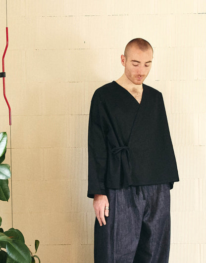 Unisex kimono, straight cut, oversized, low armholes, quilted strap at the bottom of the sleeves to modify volume, asymmetrical lines, cross-over front, closes with cotton taffeta ties of different widths. Designed to be worn both closed and open as an overshirt.
Made in France, in a Black stretch cotton gabardine, 98% Cotton, 2% Elastane, 251g/m², from a fashion house's dead stock.