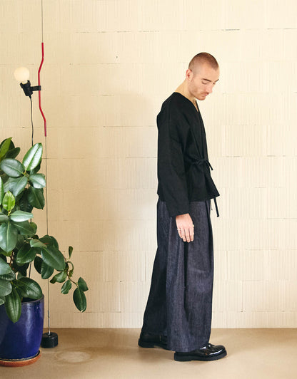 Unisex kimono, straight cut, oversized, low armholes, quilted strap at the bottom of the sleeves to modify volume, asymmetrical lines, cross-over front, closes with cotton taffeta ties of different widths. Designed to be worn both closed and open as an overshirt.
Made in France, in a Black stretch cotton gabardine, 98% Cotton, 2% Elastane, 251g/m², from a fashion house's dead stock.