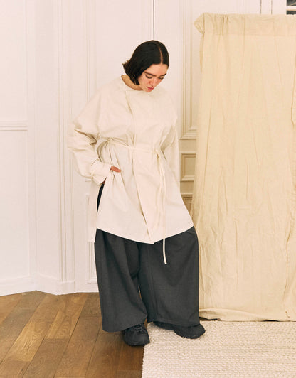 Unisex shirt, straight cut, oversized, raglan armholes, strap on the cuffs to play with the sleeves’ volume, slit on the sides, closes with two buttons on front to vary wear. Two side loops with a cotton taffeta belt also let you play with volume.
Made in France, in an Off-white textured cotton canvas, 100% cotton, 206.9g/m², from a fashion house's dead stock.