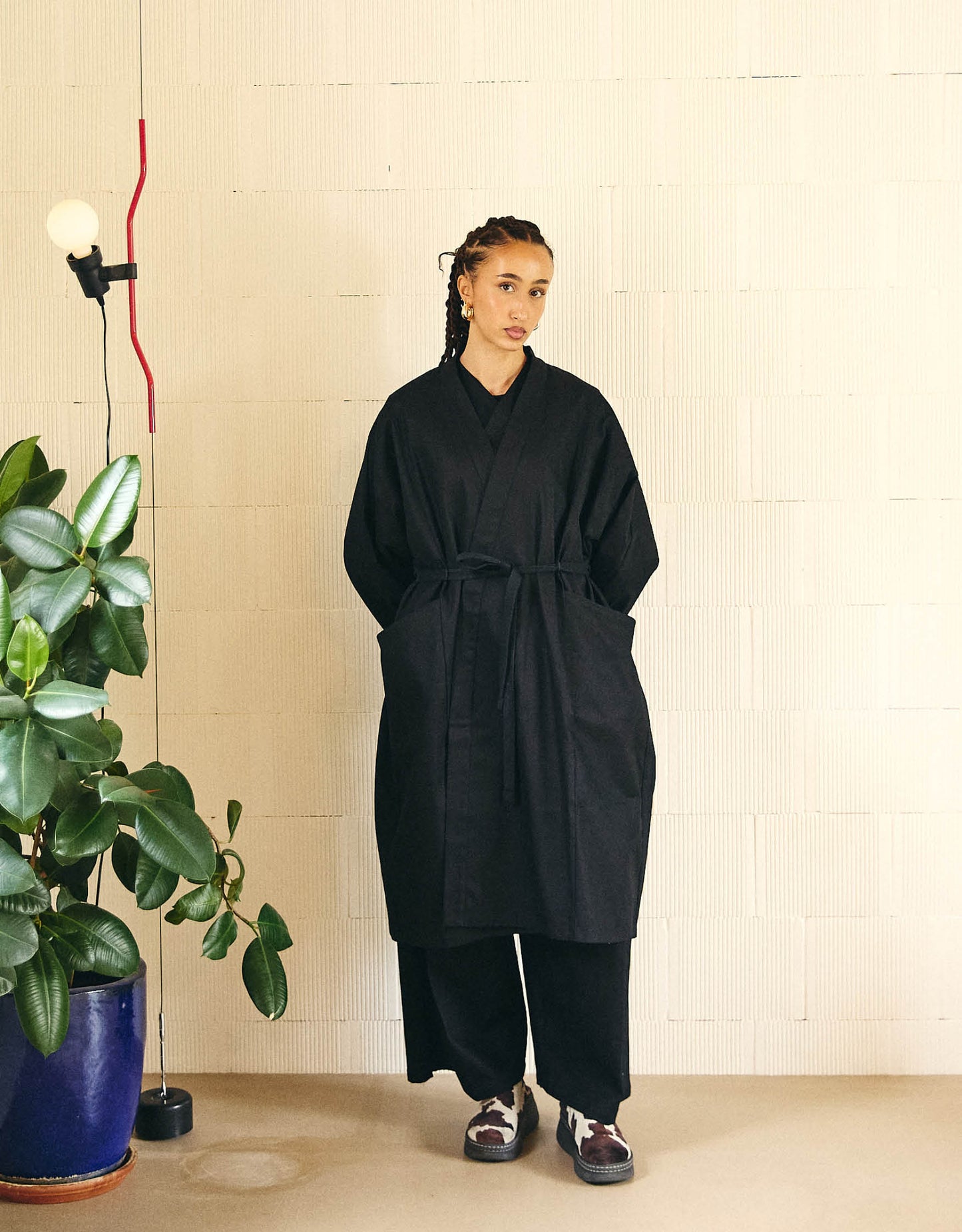 Unisex light coat, straight cut, oversized, low armholes, quilted strap at bottom of sleeves to modify volume, two wide pockets, asymmetrical lines, two wide pleats in back, cross-over front, closed by a belt.
Made in France, in a Black stretch cotton gabardine, 98% Cotton, 2% Elastane, 251g/m², from a fashion house's dead stock.
