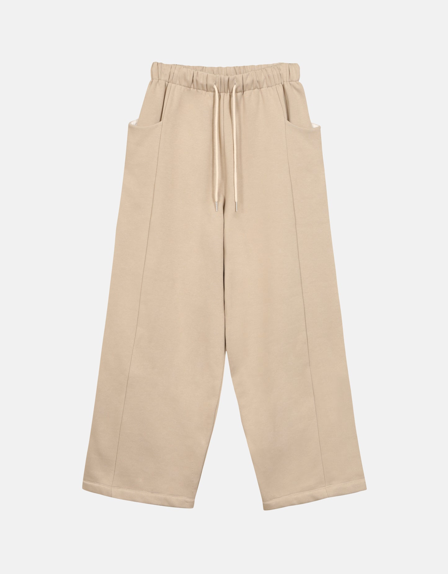 Pantalon - Chapitre 1, unisexe, jambes amples et droites, deux poches latérales, ceinture élastiquée, ajustable avec un cordon, dans un molleton gratté beige. Pants - Chapter 1, unisex, wide, straight legs, two side pockets, elasticated belt, adjustable with drawstring, in a beige brushed cotton fleece. Chaque pièce est numérotée.