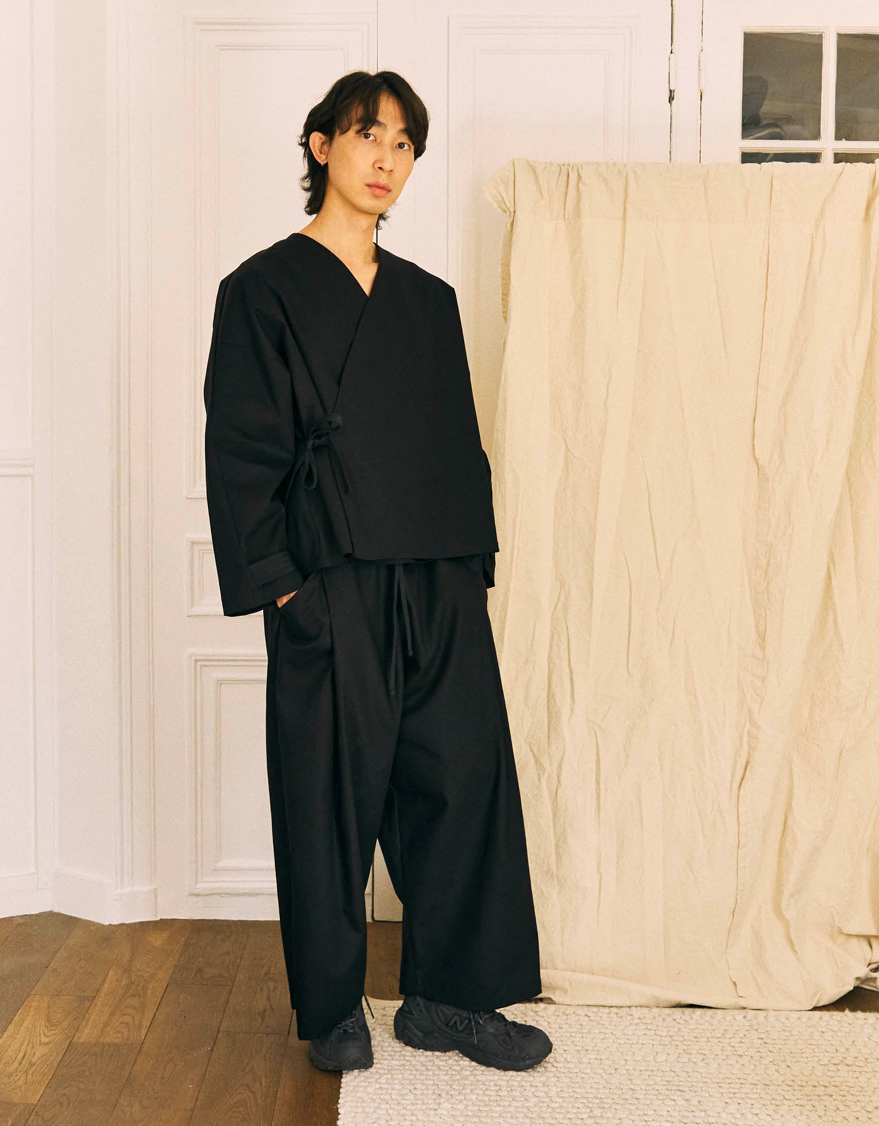 Unisex pants, wide legs, slightly flared, two generous pleats on each leg, framing the pockets, elasticated waistband adjustable with a toned-in cotton taffeta tie.
Made in France, in a Black stretch cotton gabardine, 98% Cotton, 2% Elastane, 251g/m², from a fashion house's dead stock.