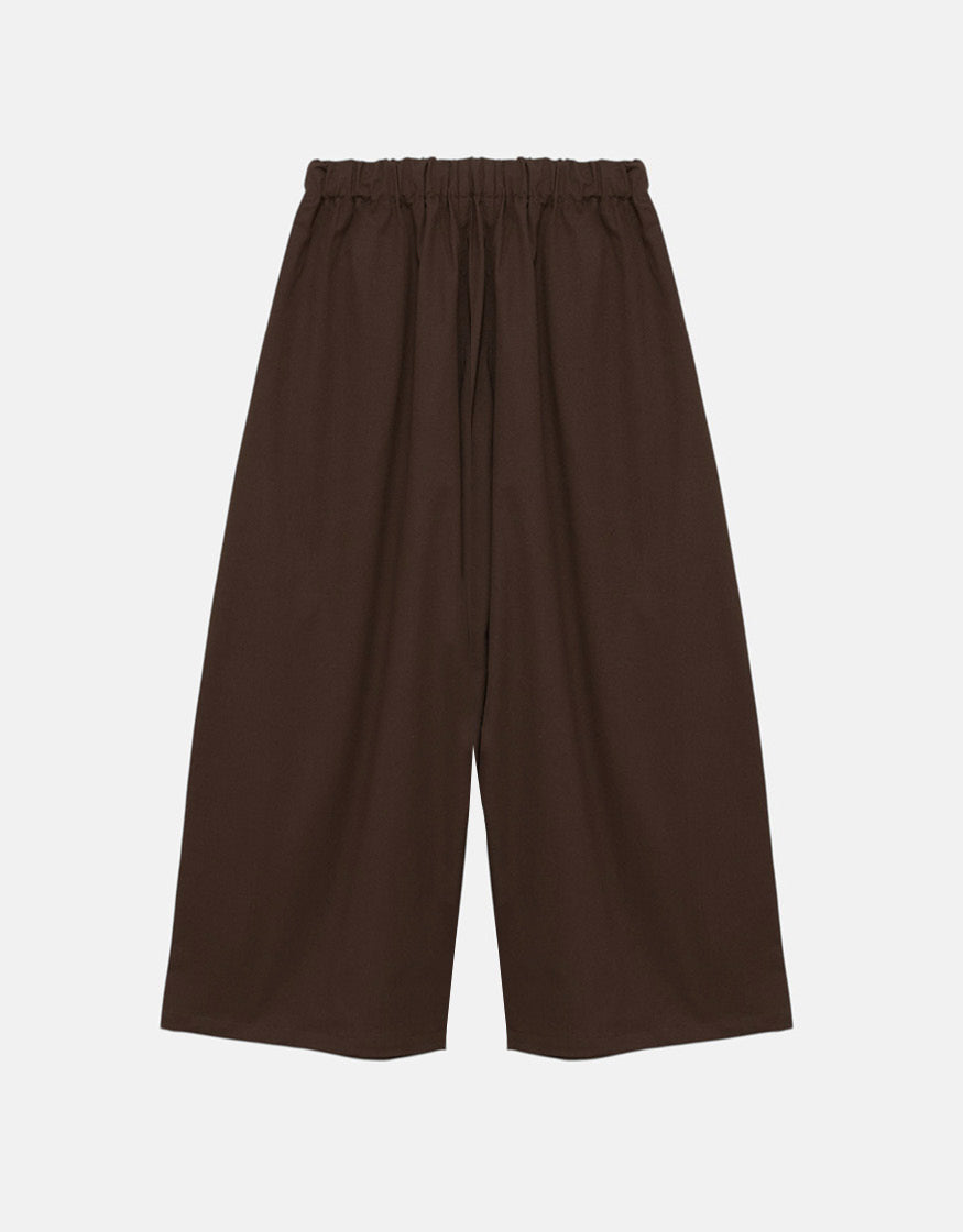 Unisex wide-leg pants in a tobacco color featuring a minimalist design with an elastic waistband for comfort and freedom of movement.