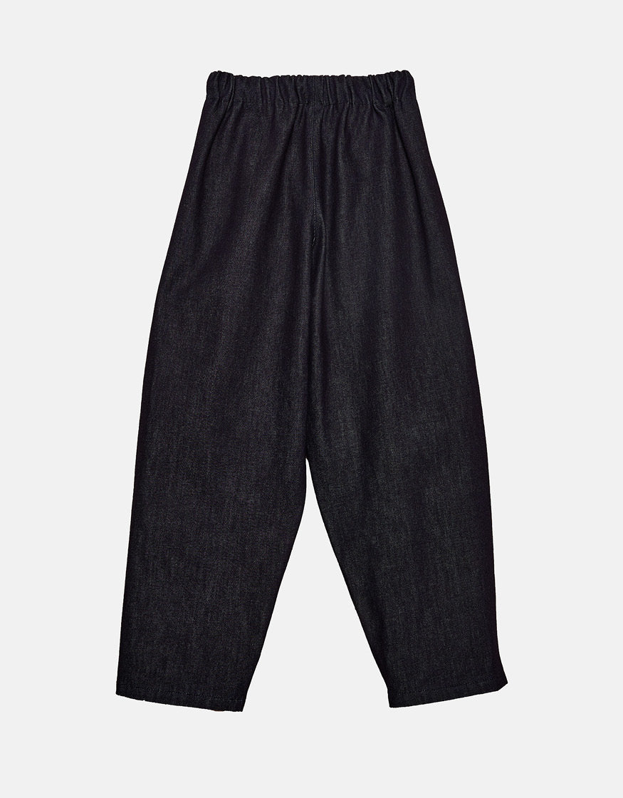 Minimalist unisex indigo pants with a relaxed fit and elastic waistband, designed for comfort and freedom of movement with subtle volume and contemporary silhouette.