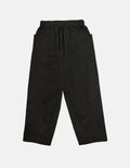 Black tapered pants with an elastic waistband and drawstring, featuring minimalist design and subtle volume for ease of movement and understated elegance.