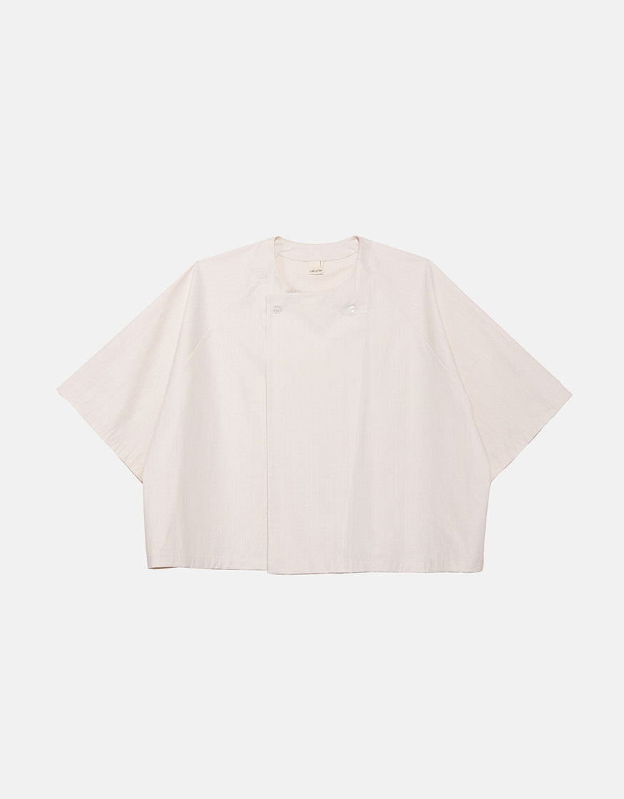 Off-white minimalist short sleeve shirt with wide, boxy silhouette and subtle asymmetrical front detail, crafted for understated elegance and comfortable movement.