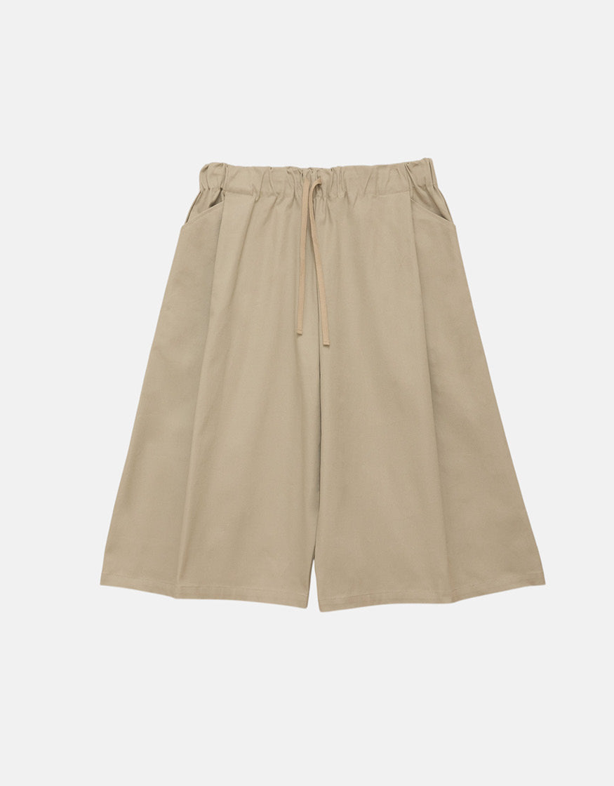 Beige wide-leg shorts with a straight cut and elastic waistband featuring a drawstring, showcasing minimalist unisex design and high-quality craftsmanship.