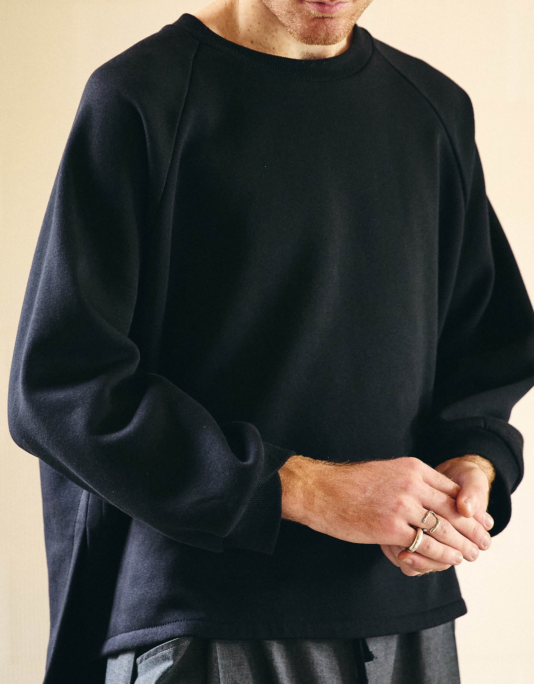 Unisex sweatshirt, straight cut, oversized, raglan sleeves, slit on the sides and longer back and wrapped detail on the ribbed cuffs.
Made in France, in an Black brushed fleece, 70% cotton, 30% polyester, 280 g/m².