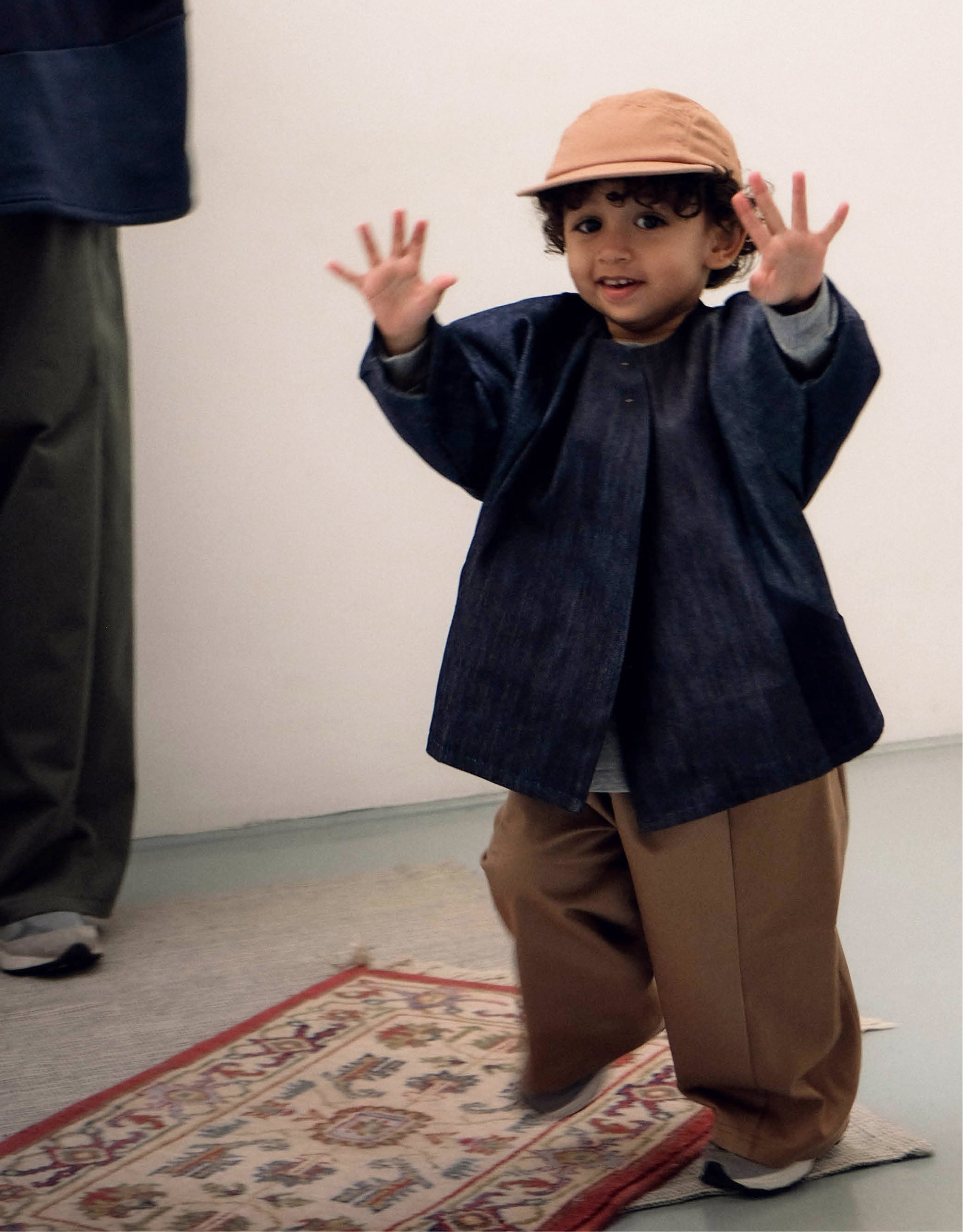 Veste pour enfant, en denim brut, coupe droite oversized, emmanchures basses, découpes asymétriques, deux poches. Fermée par une pression. Upcyclé et unisexe. Made in France. Kid jacket, in denim, oversized straight cut, low armholes, asymmetrical line, two pockets. Snap closure. Upcycled and unisex. Made in France.