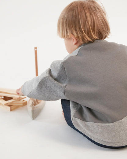 Sweatshirt pour enfant, gris, coupe droite oversized, emmanchures basses, découpes asymétriques. Upcyclé et unisexe. Made in France. Kid sweatshirt, grey, oversized straight cut, low armholes, asymmetrical lines. Upcycled and unisex. Made in France. 